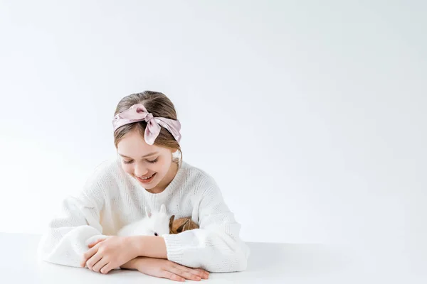 Belle fille heureuse jouer avec adorables lapins à fourrure sur blanc — Photo de stock