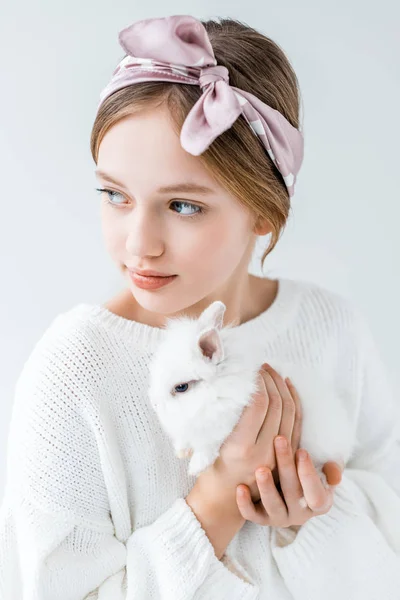 Adorable child holding furry white rabbit and looking away isolated on white — Stock Photo