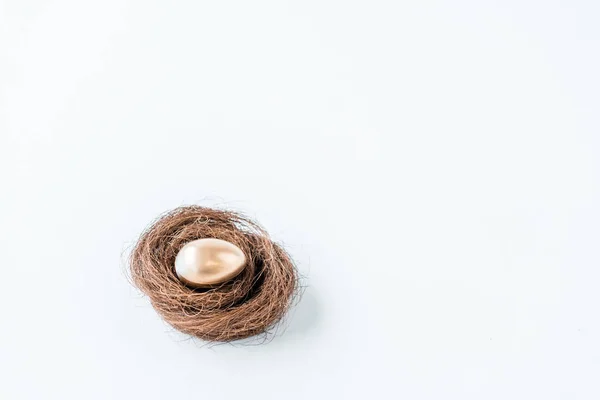 Close-up view of shiny golden easter egg in nest isolated on white — Stock Photo