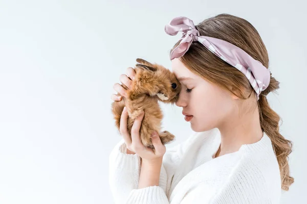 Side view of beautiful little girl holding furry rabbit isolated on white — Stock Photo