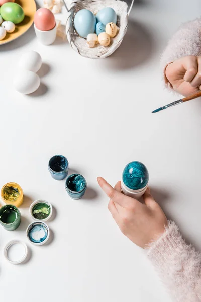 Primo piano vista parziale di bambino pittura uovo di Pasqua a tavola — Foto stock