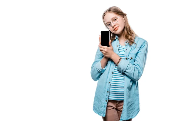 Мила дівчина в окулярах тримає смартфон з порожнім екраном і дивиться на камеру ізольовано на білому — стокове фото