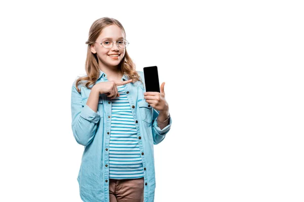 Smiling teenage girl holding smartphone and pointing with finger at blank screen isolated on white — Stock Photo