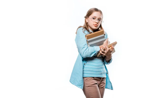 Bonito adolescente menina no óculos segurando pilha de livros e olhando para câmera isolada no branco — Fotografia de Stock