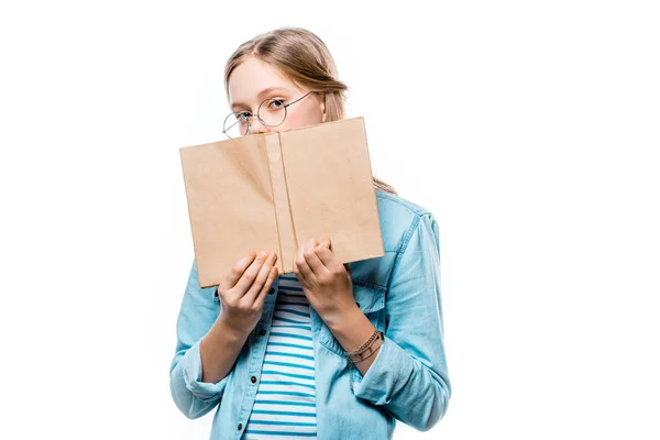 Adolescente en gafas que sostiene el libro con la cubierta en blanco y mirando la cámara aislada en blanco - foto de stock