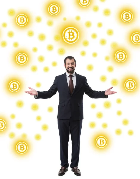 Alegre exitoso hombre de negocios en traje mirando a la cámara, símbolos bitcoin aislados en blanco - foto de stock