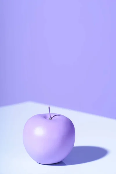 Purple apple on violet background with copy space — Stock Photo