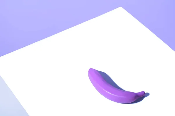 Plastic purple banana on white surface — Stock Photo