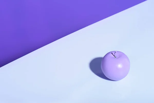 Purple apple on violet background with copy space — Stock Photo