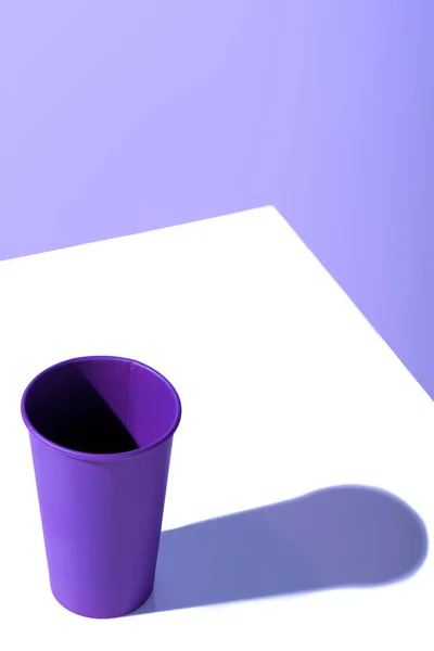 Tasse jetable en plastique violet, sur surface blanche avec espace de copie — Photo de stock