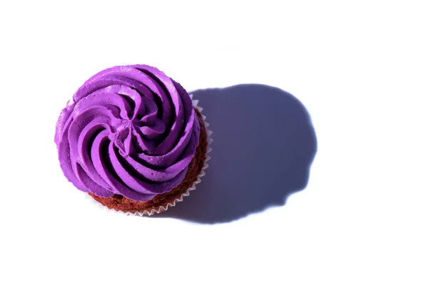 Top view of cupcake with purple buttercream icing, on white surface — Stock Photo