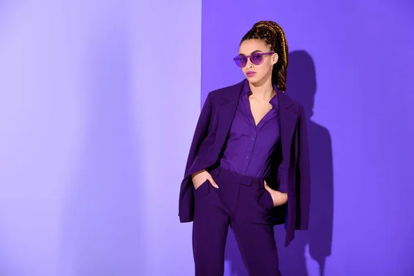 Stylish african american girl posing in purple suit and sunglasses, ultra violet trend — Stock Photo