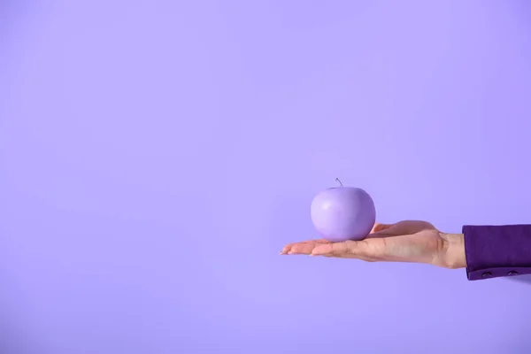 Cropped view on female hand holding purple apple, isolated on ultra violet — Stock Photo