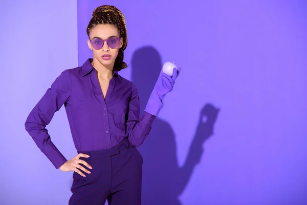 Stylish african american girl in rubber glove holding purple apple, ultra violet trend of 2018 year — Stock Photo