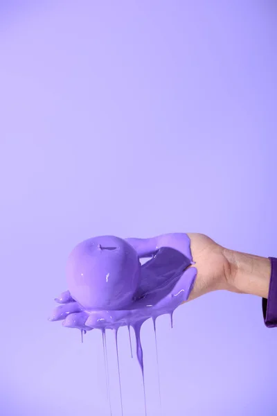 Cropped view on female hand holding apple in purple paint, isolated on ultra violet — Stock Photo