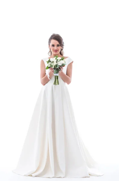 Glückliche junge Braut posiert in traditionellem weißen Kleid mit Brautstrauß, isoliert auf weiß — Stockfoto