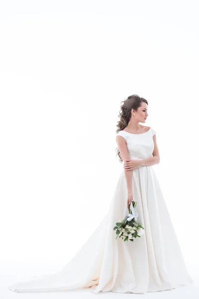 Елегантна наречена позує в традиційній білій сукні з весільним букетом, ізольована на білому — стокове фото