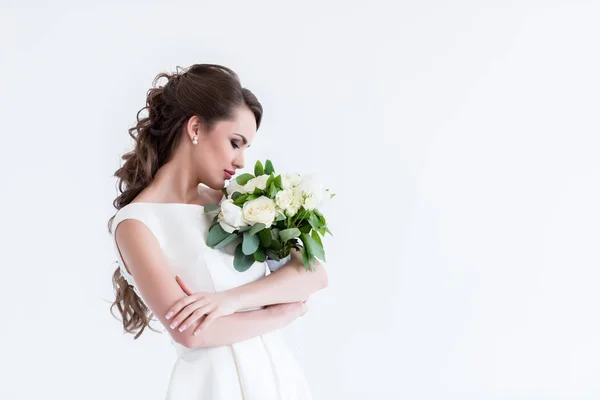 Hermosa novia olfateando ramo de boda, aislado en blanco - foto de stock