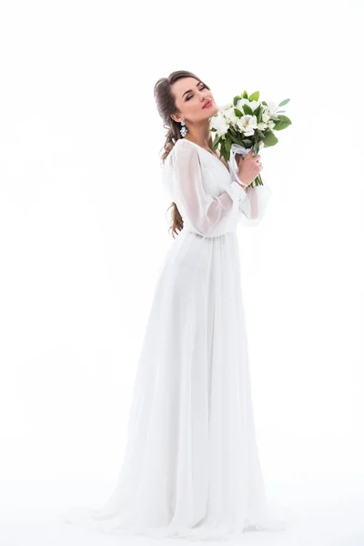 Dreamy bride posing in dress with wedding bouquet, isolated on white — Stock Photo