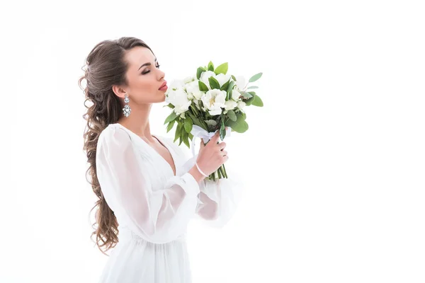 Jolie mariée en robe blanche reniflant bouquet de mariage, isolé sur blanc — Photo de stock