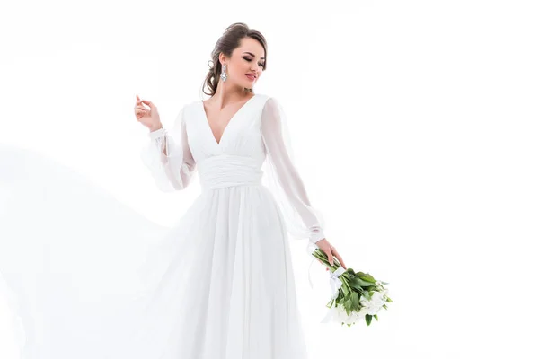 Щаслива наречена позує в традиційній сукні з весільним букетом, ізольована на білому — стокове фото