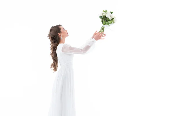 Noiva elegante em vestido branco jogando buquê de casamento, isolado no branco — Fotografia de Stock