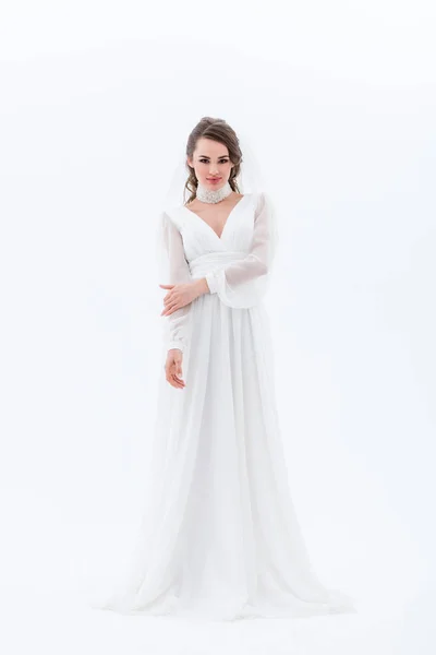 Красива усміхнена наречена позує в традиційній весільній сукні, ізольована на білому — стокове фото