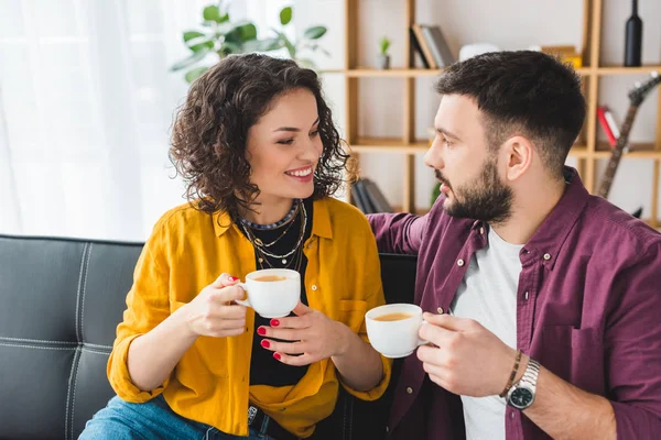 Mujer sonriente tomando café con su novio - foto de stock