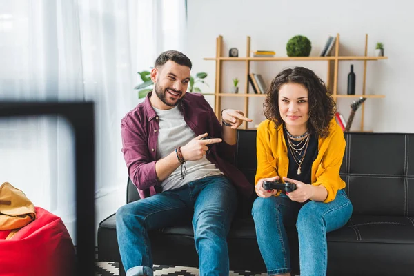 Man pointing fingers at his girlfriend while she holding joystick — Stock Photo
