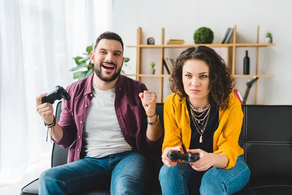 Jeune couple jouant jeu vidéo avec joysticks — Photo de stock