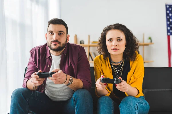 Vista frontal do jovem casal segurando joysticks nas mãos — Fotografia de Stock