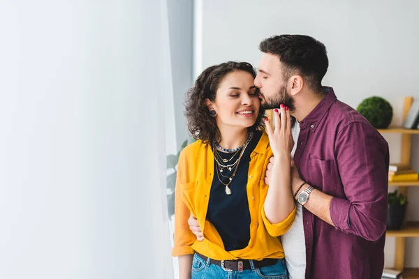 Uomo baciare guancia della sua ragazza sorridente — Foto stock