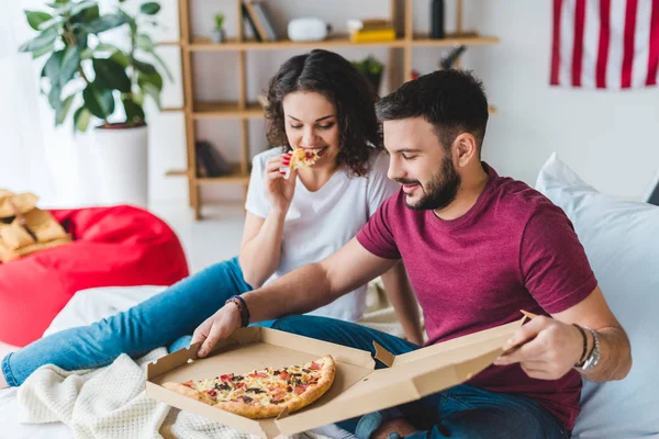 Man holding box with pizza with sitting girlfriend beside — Stock Photo