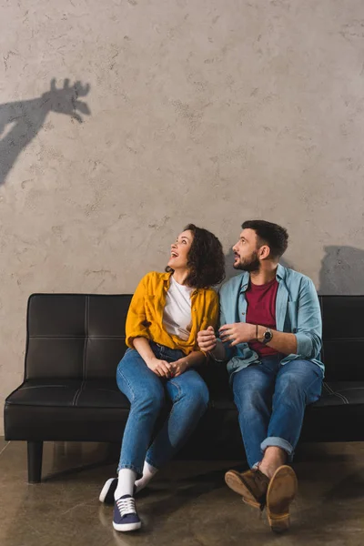 Shadow on wall and couple sitting on couch — Stock Photo