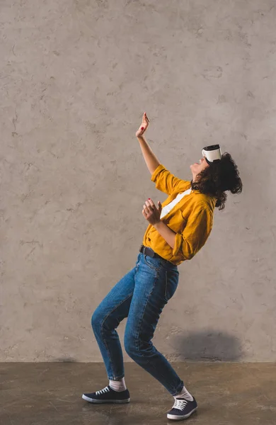 Vista lateral de la mujer sorprendida con auriculares de realidad virtual - foto de stock