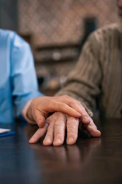 Caregiver supporting and holding hand of senior man — Stock Photo