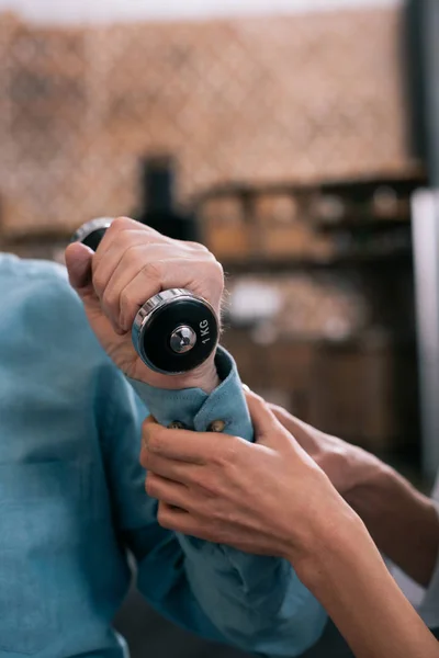 Close-up view of doctor helping senior man exercising with dumbbell — Stock Photo