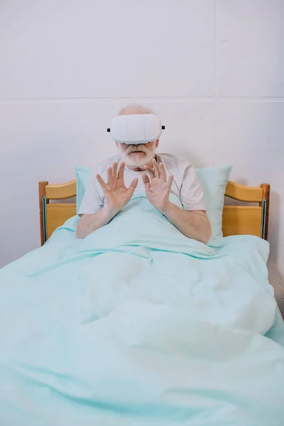 Hommes âgés dans le lit de salle d'hôpital en utilisant casque de réalité virtuelle — Photo de stock