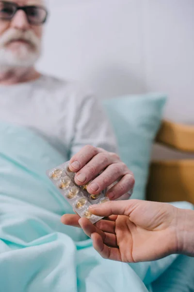Close-up view of senior patient taking medications from doctor — Stock Photo