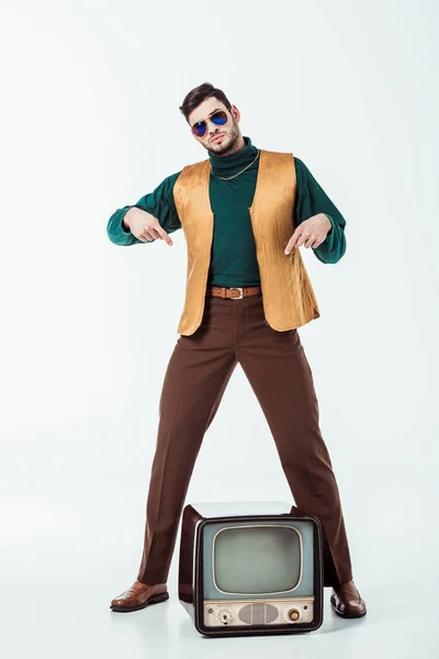 Handsome retro styled man pointing on television on white — Stock Photo