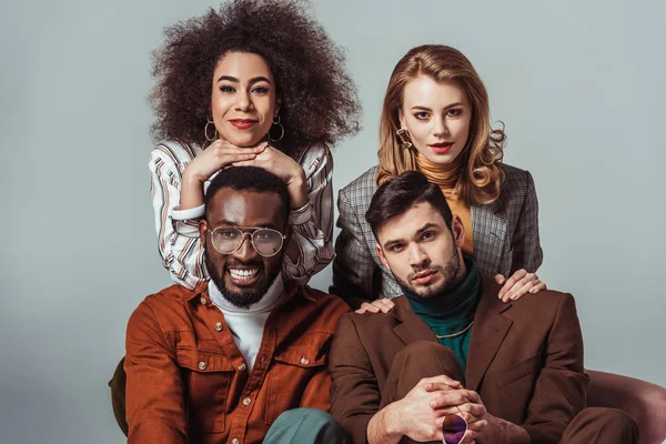 Happy multiethnic retro styled friends looking at camera isolated on grey — Stock Photo