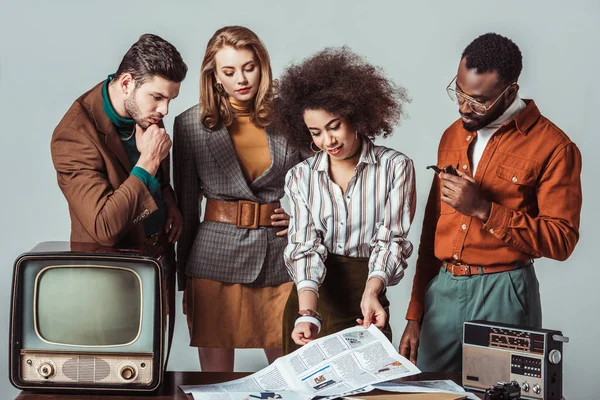 Multicultural retro styled journalists in newsroom isolated on grey — Stock Photo