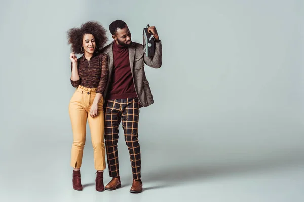 Happy african american retro styled couple with vintage radio on grey — Stock Photo