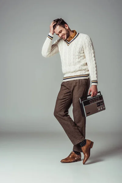 Homme élégant au style rétro souriant avec radio vintage sur gris — Photo de stock