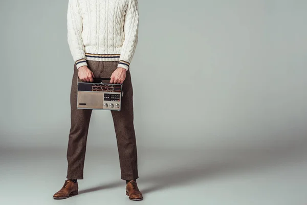 Cropped image of retro styled man holding vintage radio on grey — Stock Photo