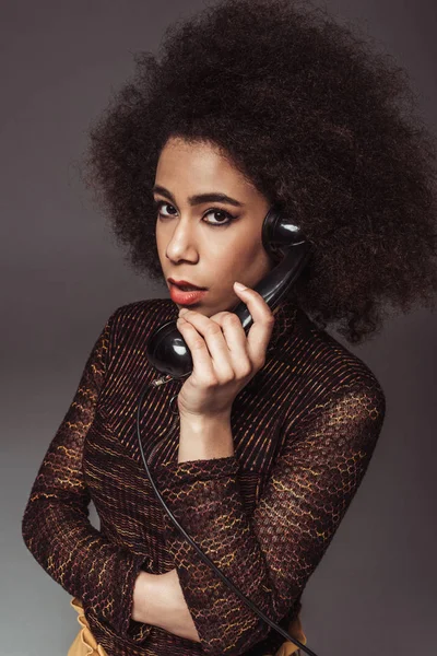 Afro americano retrò ragazza in stile parlare da vintage telefono fisso isolato su grigio — Foto stock