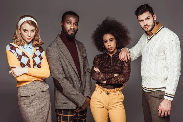 Multicultural retro styled friends looking at camera isolated on grey — Stock Photo