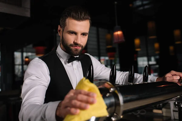 Bonito barman limpeza cerveja torneiras à noite — Fotografia de Stock