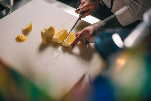 Abgeschnittenes Bild eines Mädchens, das Zitrone für Getränke schneidet — Stockfoto