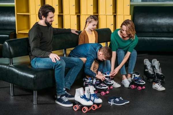 Família vestindo patins antes de patinar no parque de skate — Fotografia de Stock